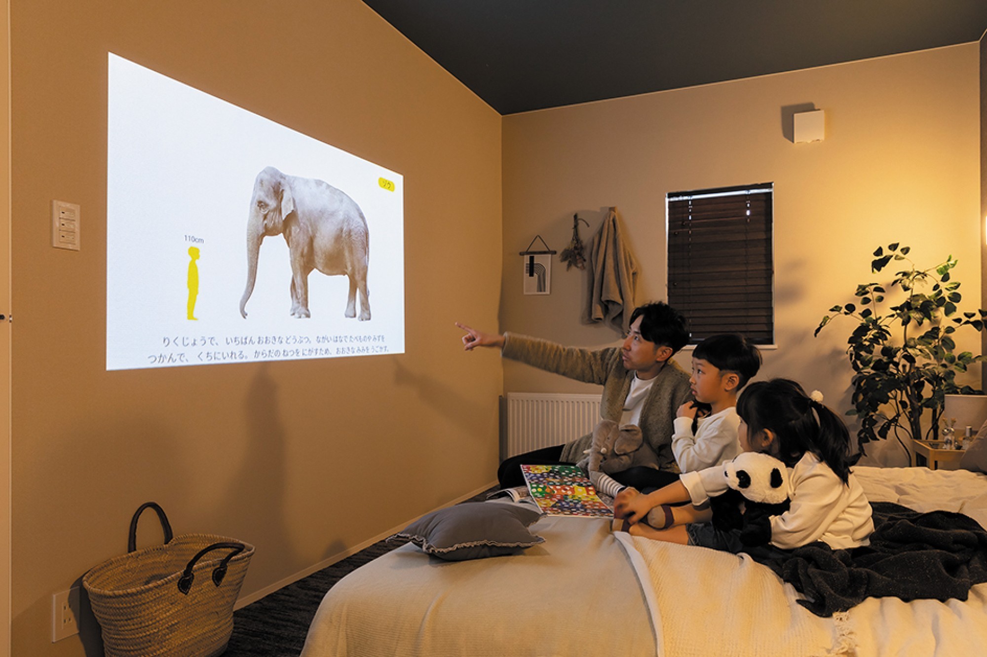 寝室の壁を使って、自宅が映画館に - 白い壁さえあれば、どこでも映画館。&nbsp;ベッドルームの照明に Aladdin X（アラジン エックス）を採用し、&nbsp;テレビや映画、動く絵本を家族みんなで楽しめます。 -  - 