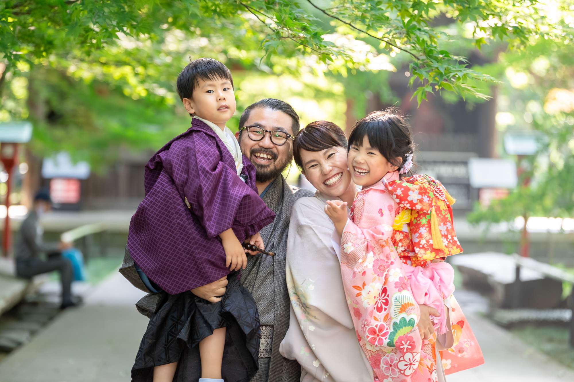 家族4人が和装、父が袴姿の男の子、母が着物姿の女の子を抱っこしている写真