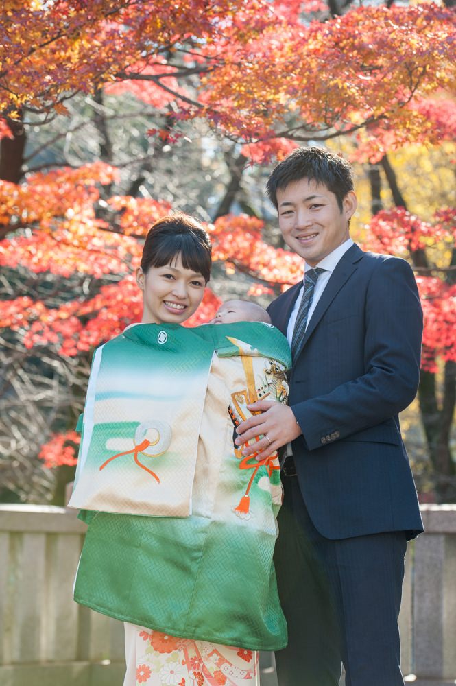  - 鮮やかな紅葉をバックに記念の1枚&nbsp;産着が鮮やかに映えます　笑顔もとっても素敵です