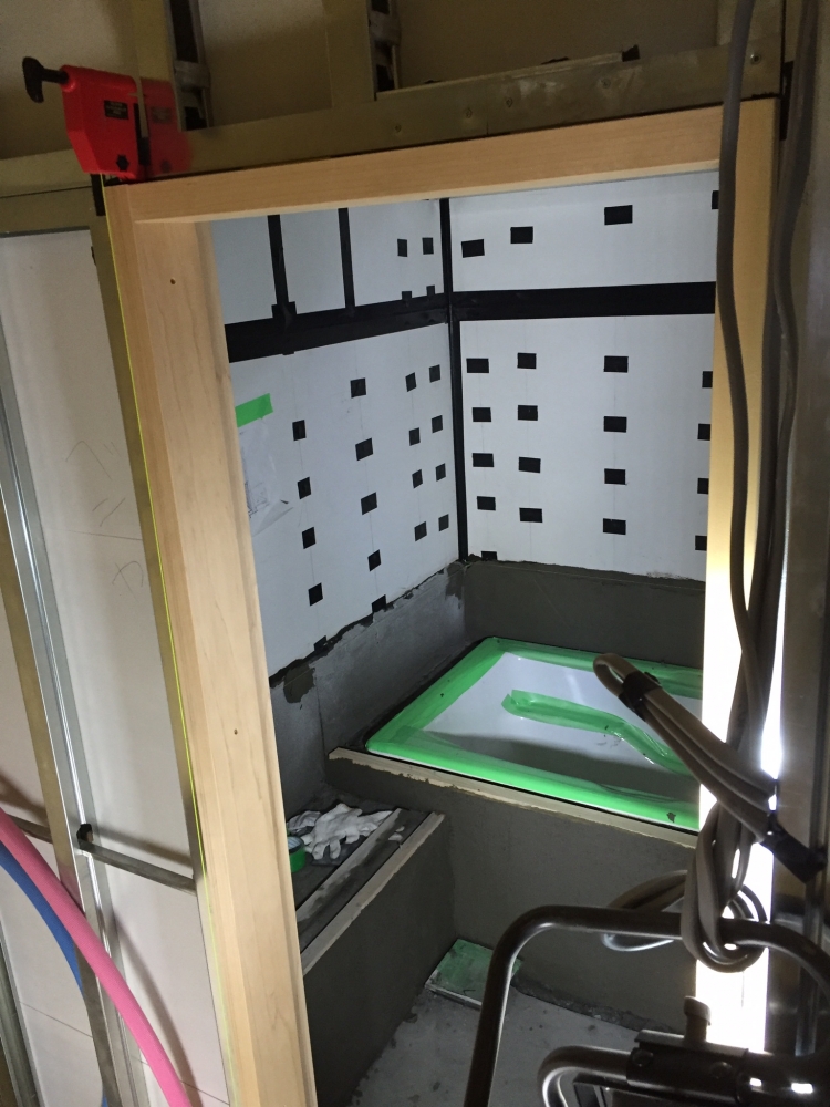 - ヒノキの入口枠を施工。 スレート面のジョイントとビス頭に防止テープを施工し湿気が逃げないようにする。枠などの取り合い部分も同様。木造の外壁の納まりに近い。 - -